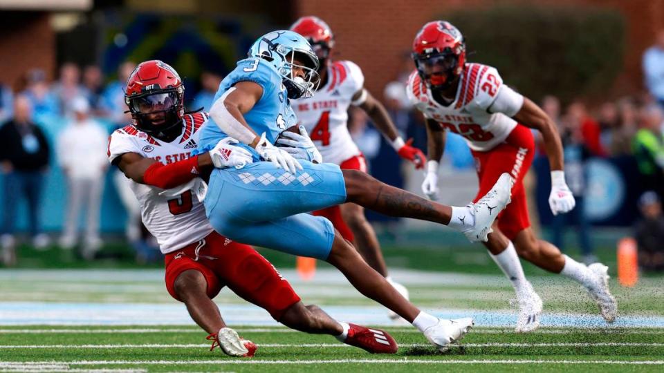 N.C. State cornerback Aydan White (3) tackles North Carolina wide receiver Antoine Green (3) during the first half of N.C. State’s game against UNC at Kenan Stadium in Chapel Hill, N.C., Friday, Nov. 25, 2022.