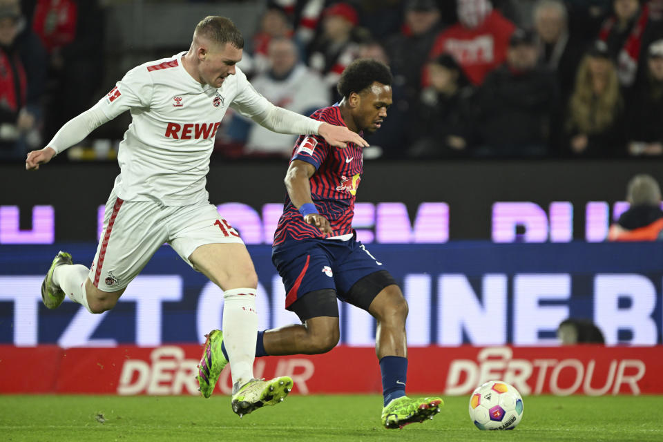Cologne's Luca Kilian, left, and Leipzig's Lois Openda battle for the ball during the Bundesliga soccer match between FC Koln and RB Leipzig at RheinEnergieStadion in Cologne, Germany, Friday March 15, 2024. (Federico Gambarini/dpa via AP)