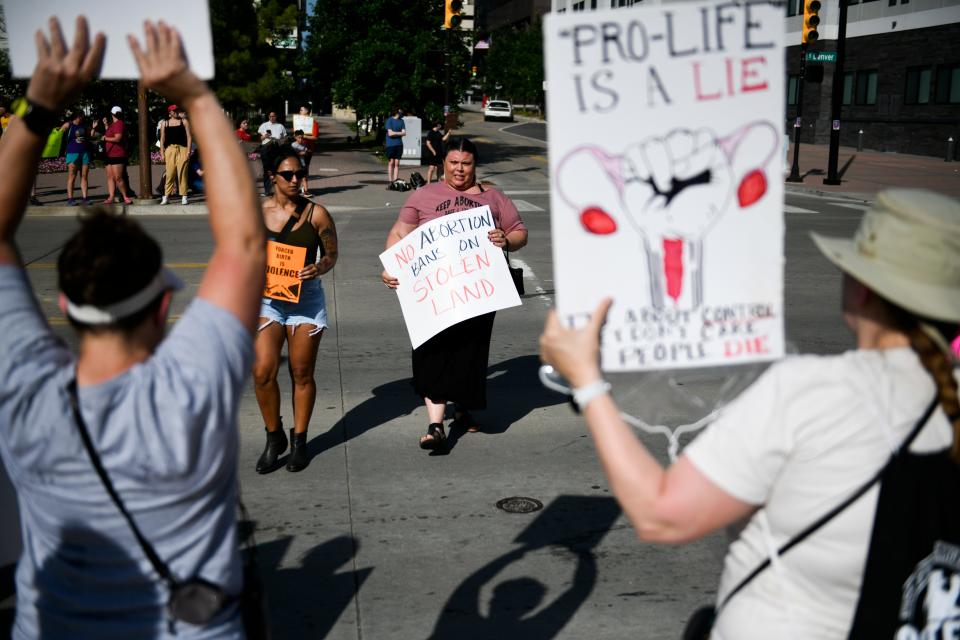 People hold hand-written posters.