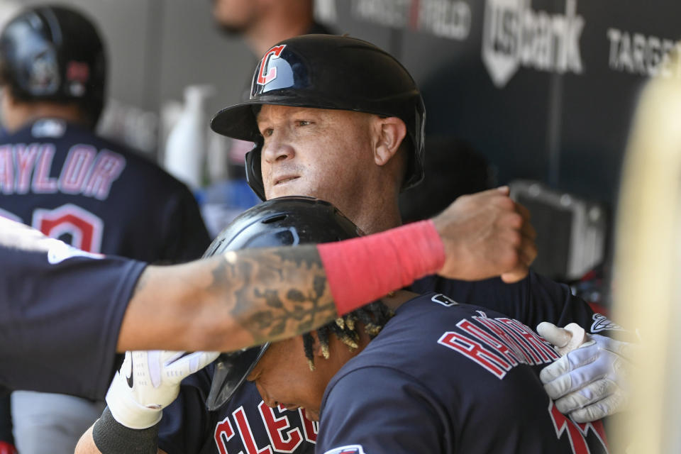 Cleveland Guardians' Kole Calhoun, top, hugs Jose Ramirez after hitting a three-run home run against the Minnesota Twins during the tenth inning of a baseball game Wednesday, Aug. 30, 2023, in Minneapolis. The Guardians won 5-2. (AP Photo/Craig Lassig)