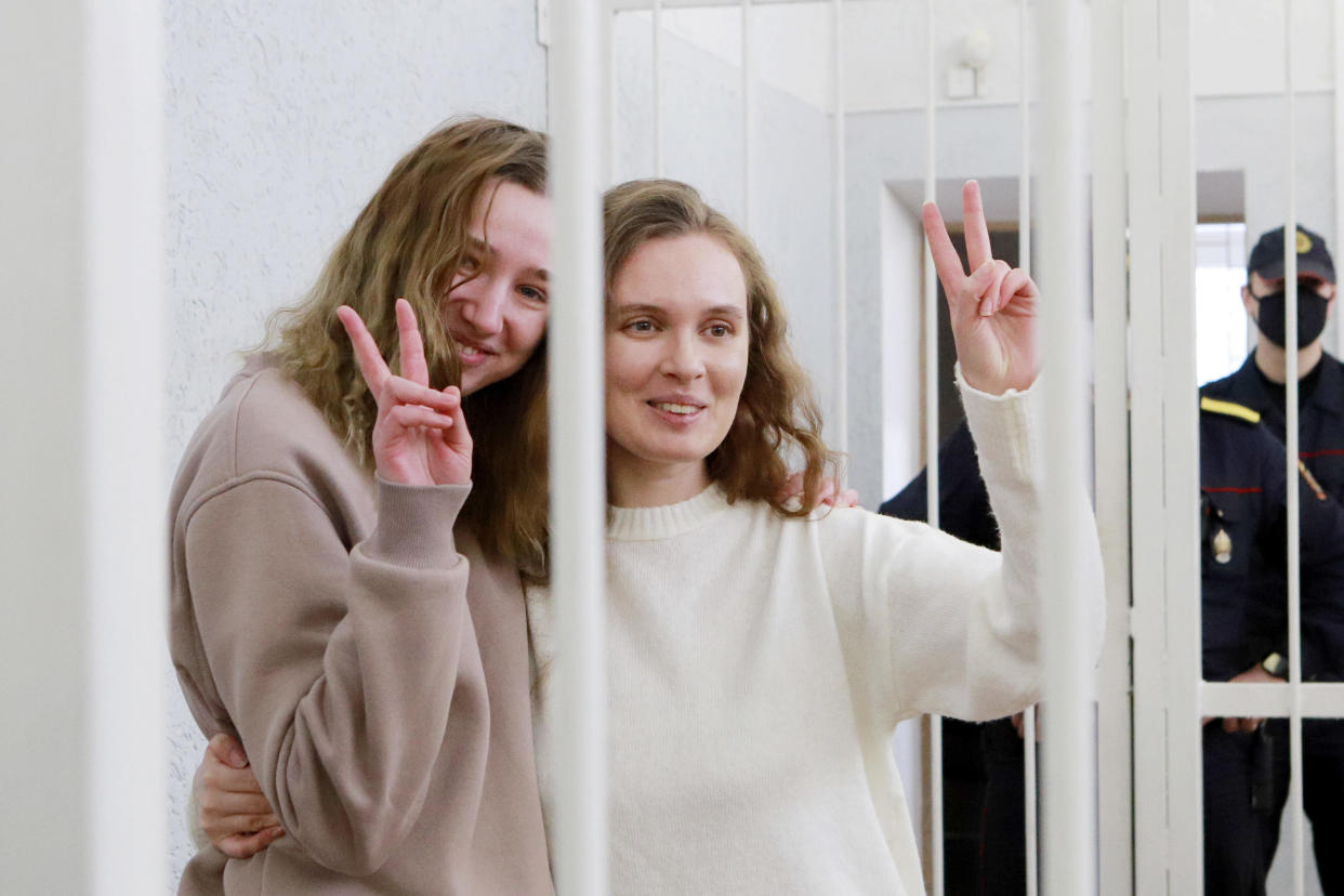 Belsat TV journalists Katerina Andreyeva (R) and Daria Chultsova, who were detained in November while reporting on anti-government protests, flash the V-sign from a defendants' cage during their trial in Minsk, February 18, 2021. / Credit: STRINGER/AFP/Getty