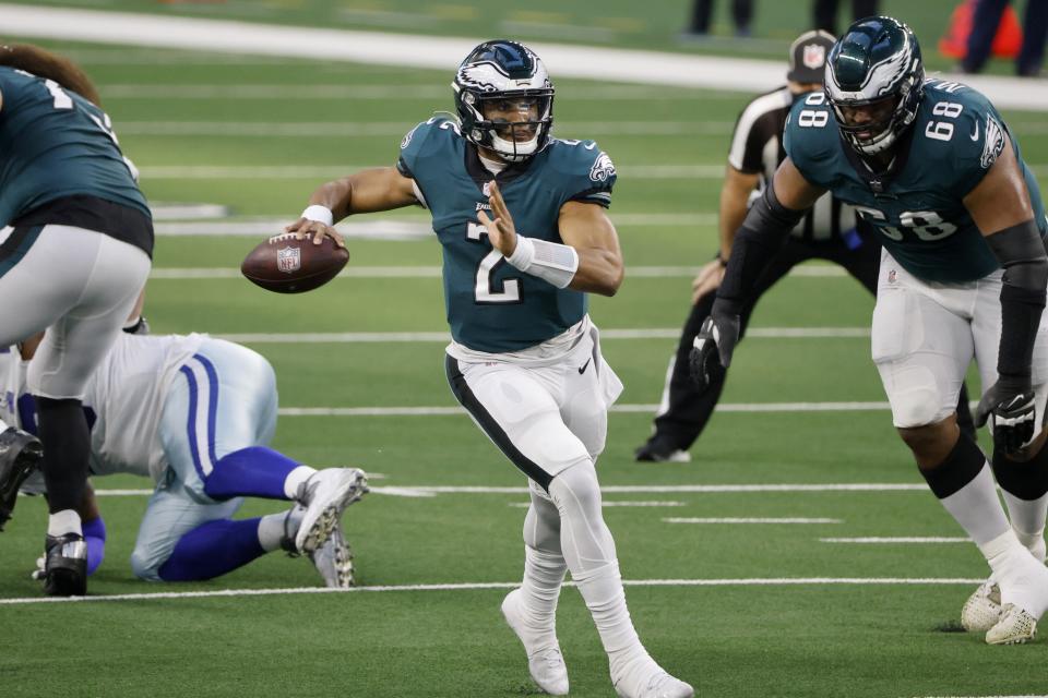 Philadelphia Eagles' Jalen Hurts (2) scrambles out of the pocket before throwing a pass with protection from offensive tackle Jordan Mailata in the first half of an NFL football game against the Dallas Cowboys in Arlington, Texas, Sunday, Dec. 27. 2020. (AP Photo/Michael Ainsworth)