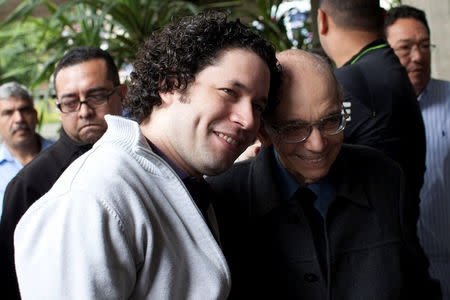 FILE PHOTO: Venezuelan conductor Gustavo Dudamel (L) and the founder of the National System of Children and Youth Orchestras of Venezuela Jose Antonio Abreu attend a free concert by the Simon Bolivar Youth Symphonic Orchestra at the Teresa Carreno theater in Caracas February 16, 2012. REUTERS/Carlos Garcia Rawlins/File Photo