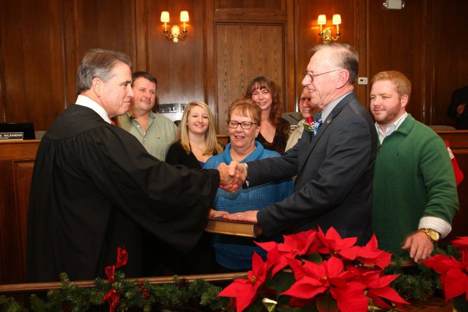 Judge Warren Clark congratulates John Kramer at his swearing-in as mayor in 2016 as Kramer''s wife Carol and family look on.