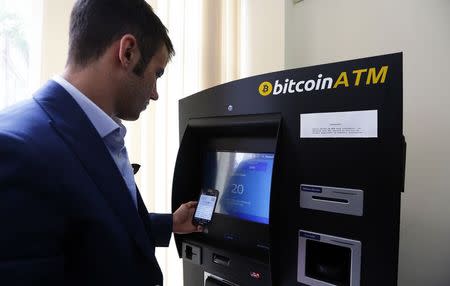 George Rotariu uses the first bitcoin ATM in downtown Bucharest June 27, 2014. REUTERS/Bogdan Cristel