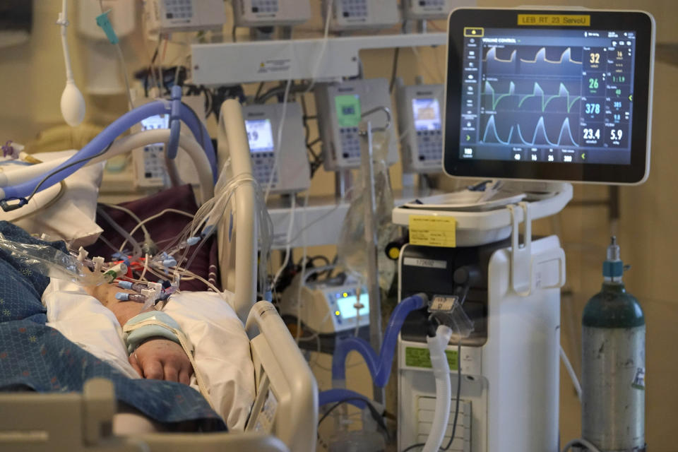 FILE - An unidentified COVID-19 patient is attached to life-support systems in the COVID-19 Intensive Care Unit at Dartmouth-Hitchcock Medical Center, in Lebanon, N.H., Jan. 3, 2022. Scientists are seeing signals that COVID-19′s alarming omicron wave may have peaked in Britain and is about to do the same in the U.S., at which point cases may start dropping off dramatically. (AP Photo/Steven Senne, File)