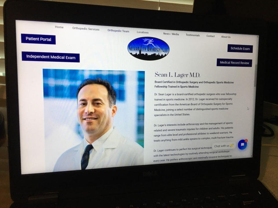 A laptop computer displays Dr. Sean Lager's photo and bio from the web site of his company, Gotham City Orthopedics.