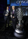 Will Power, left, winner of the 2018 Indianapolis 500, holds his "Baby Borg" driver's trophy as he stands with Roger Penske, who holds his team owner's trophy, in Detroit, Wednesday, Jan. 16, 2019. At right is the Borg-Warner Trophy. (AP Photo/Paul Sancya)