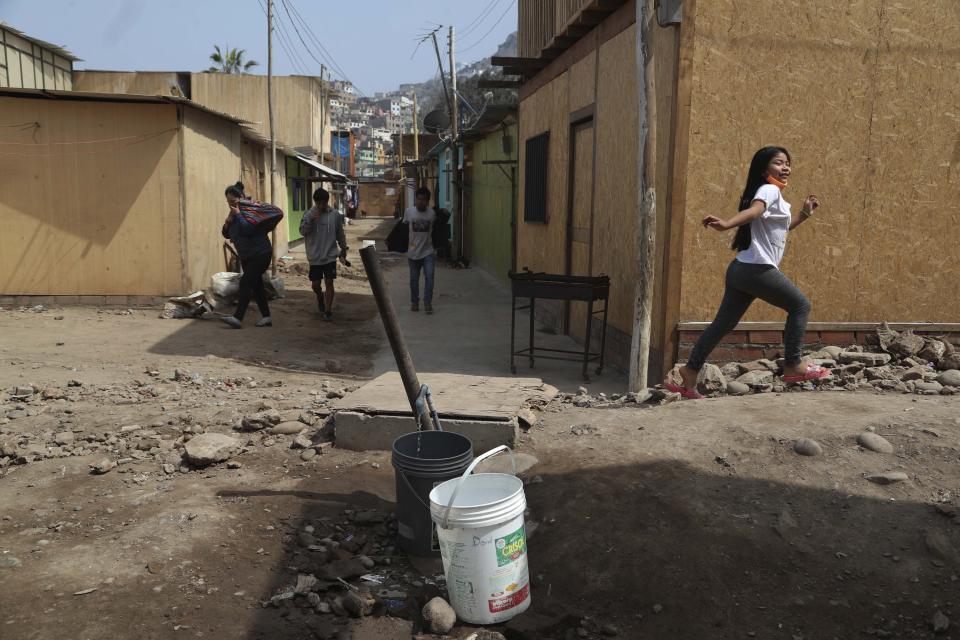 Buckets sit under a tap collecting water in the Cantagallo neighborhood of Lima, Peru, Thursday, Sept. 24, 2020. The Cantagallo neighborhood – rooster’s crow, in English – does not have regular water or electricity. Since 2013, officials have pledged improvements. Two city mayors who promised housing have been implicated in Latin America’s largest graft probe. (AP Photo/Martin Mejia)