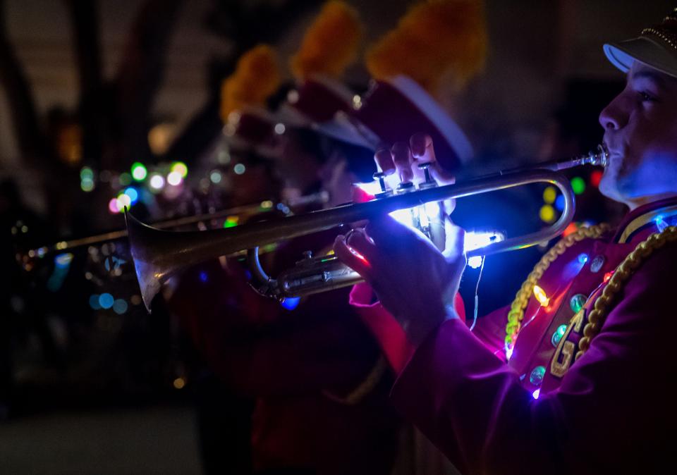 The Pacific Grove High School band members play their instruments in front of dozens of spectators during the annual Holiday Parade of Lights in Pacific Grove, Calif., on Thursday Dec. 2, 2021. 