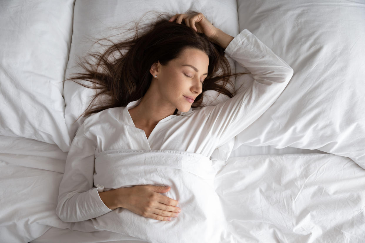 Woman sleeping in bed wearing pyjamas