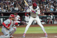 St. Louis Cardinals catcher Willson Contreras, left, drops a pitch allowing Diamondbacks' Corbin Carroll to steal second base as Diamondbacks' Lourdes Gurriel Jr., right, looks on during the first inning of a baseball game Friday, April 12, 2024, in Phoenix. (AP Photo/Ross D. Franklin)
