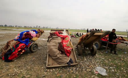 Carts loaded with bodies of civilians killed in air strike, are seen during a battle between Iraqi forces and Islamic State militants, in Mosul, Iraq March 17, 2017. REUTERS/Thaier Al-Sudani