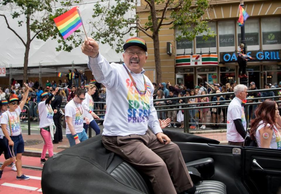 San Francisco Mayor Ed Lee waves to a cheering crowd along the San Francisco Pride parade route in San Francisco, California on June 25, 2017.