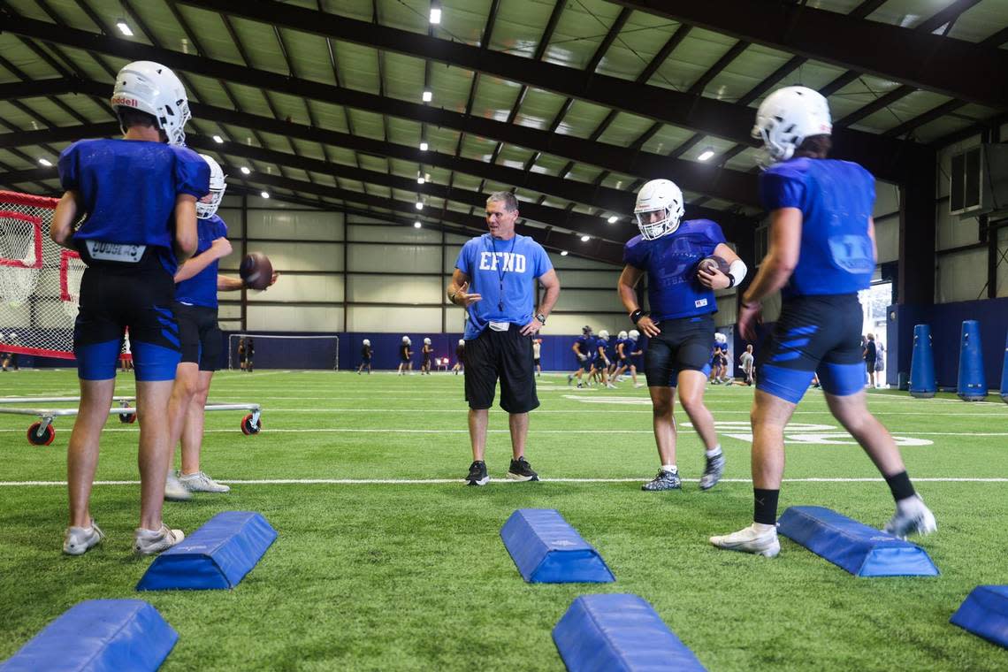 Decatur head coach Steven Huff chats with players while they run drills during practice. Huff left his position at College Station to become the head coach of the Decatur Eagles this spring.