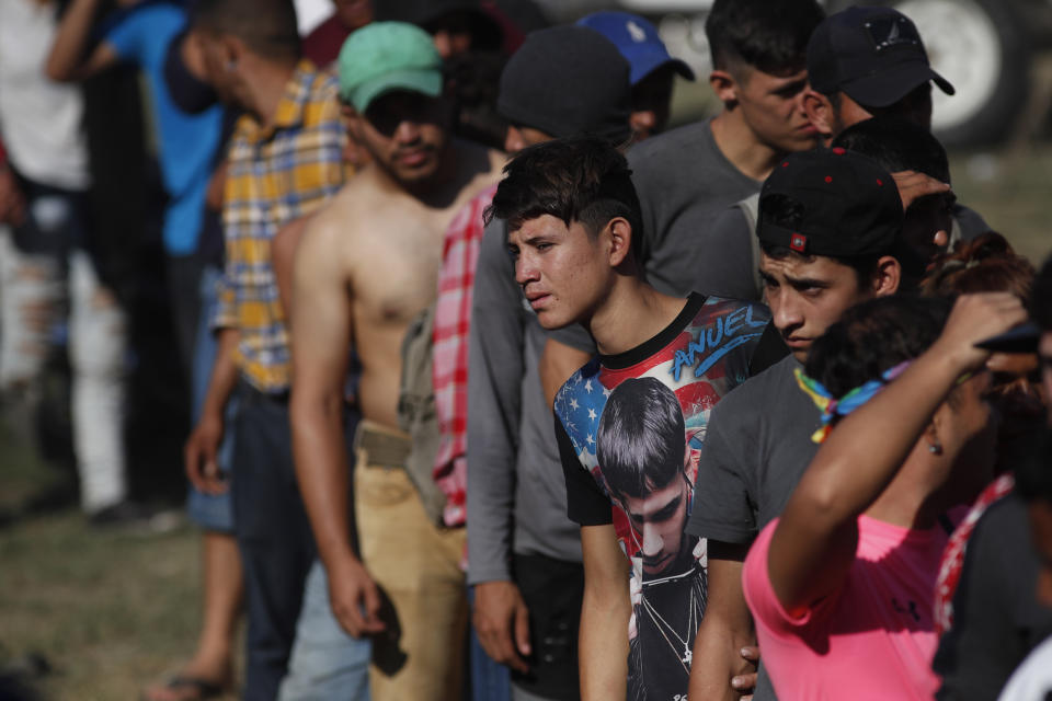 Migrants stand in line for breakfast at a temporary shelter in Tecun Uman, Guatemala in the border with Mexico, Sunday, Jan. 19, 2020. Mexican authorities have closed a border entry point in southern Mexico after thousands of Central American migrants tried to push across a bridge between Mexico and Guatemala. (AP Photo/Moises Castillo)