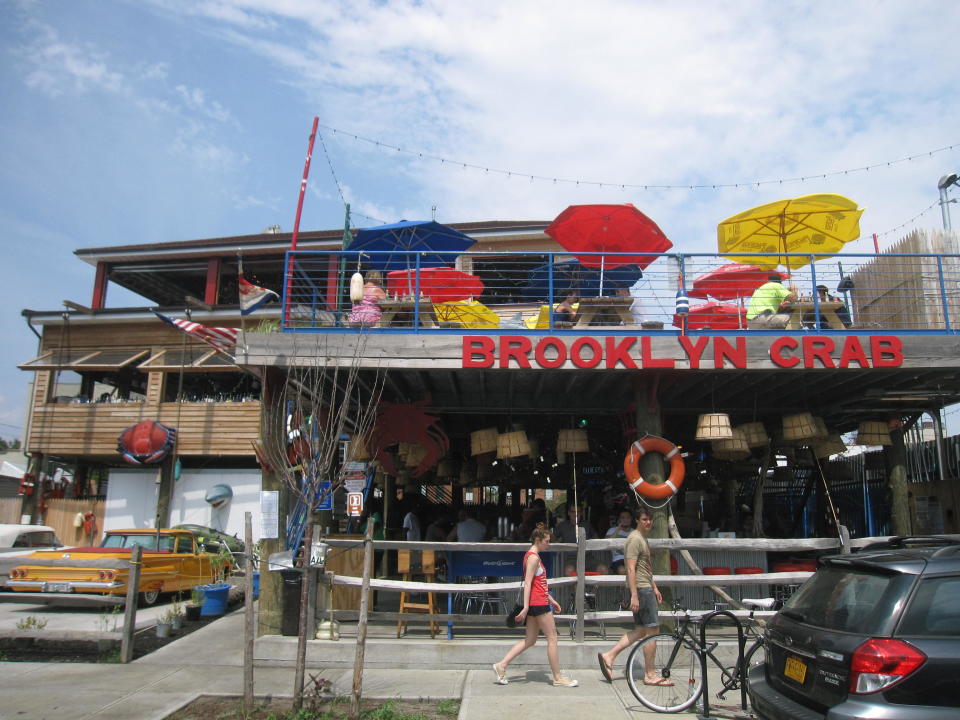 This July 20, 2013 photo shows the exterior of Brooklyn Crab in Red Hook, a popular seafood eatery in a working-class industrial neighborhood in New York City’s Brooklyn borough. The restaurant offers a view of the Brooklyn waterfront and is located across from old brick warehouses that now house a supermarket. Red Hook’s restaurants and shopping have begun to attract a steady stream of New Yorkers and out-of-towners alike. (AP Photo/Beth J. Harpaz)