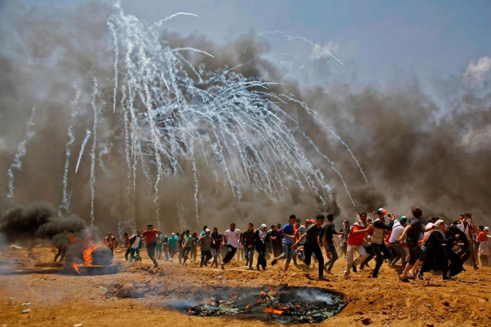 Protesters in Gaza run from teargas shells fired by Israeli forces (Getty Images)