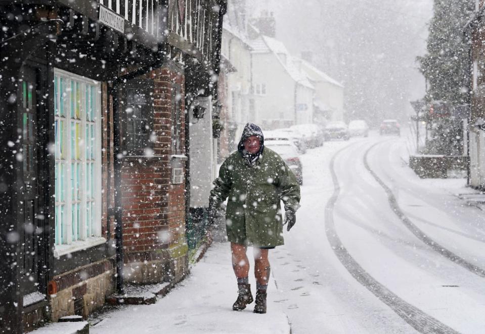 A man walks down a street in Lenham, Kent, as the town was covered in snow (PA)