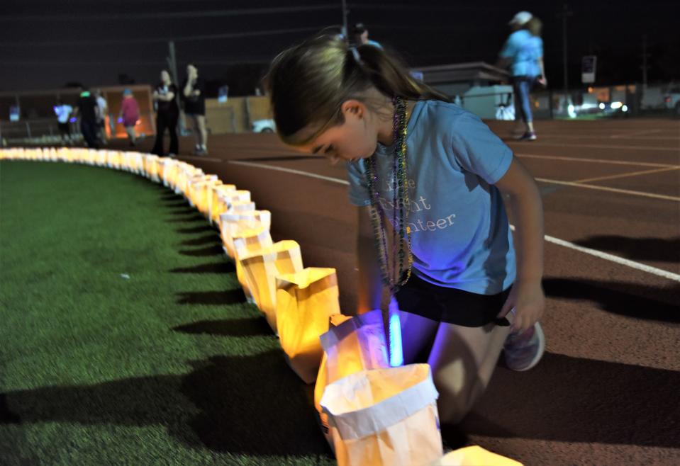 Reese Bitzkie, 7, places lights in memorial bags during the luminaria ceremony at the Relay for Life of Southern Bastrop County event on Saturday at Erhard Field.