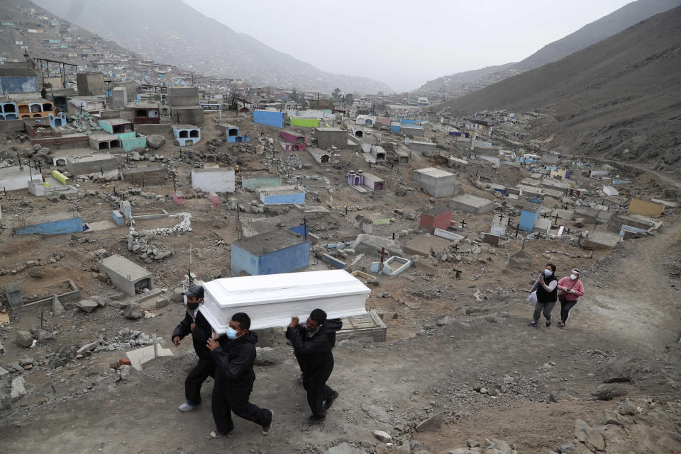 Trabajadores de un cementerio cargan el ataúd con los restos de Wilson Gil, cuyos familiares afirman que falleció por complicaciones relacionadas con el COVID-19, para ser enterrado en el Cementerio "Mártires 19 de Julio", en las afueras de Lima, Perú, el miércoles 26 de agosto de 2020. El país sudamericano registra la mayor cantidad de contagios de coronavirus en América Latina detrás de Brasil. (AP Foto/Martín Mejía)