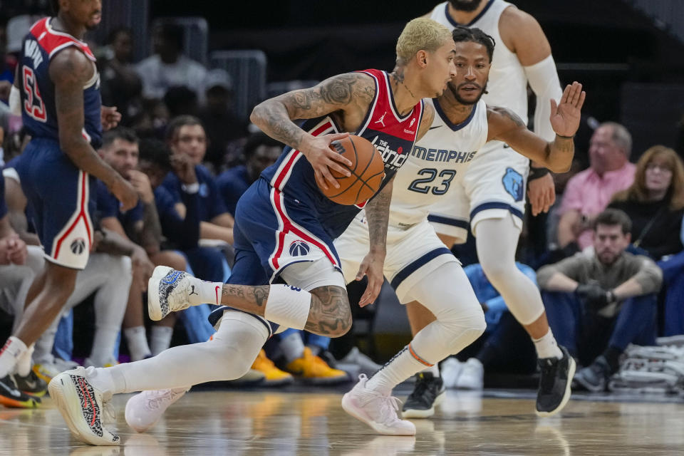 Washington Wizards forward Kyle Kuzma, front center, drives against Memphis Grizzlies guard Derrick Rose (23) during the first half of an NBA basketball game Saturday, Oct. 28, 2023, in Washington. (AP Photo/Alex Brandon)