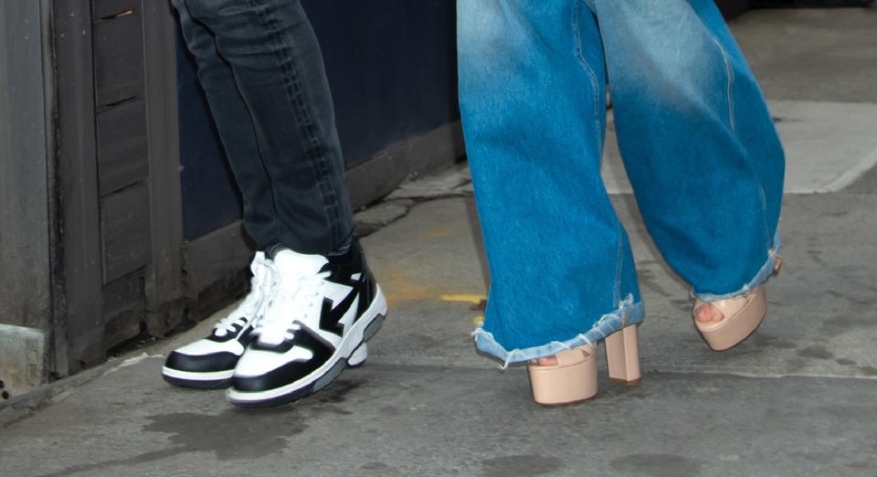 A close-up of Ben Affleck’s Off-White “Out-Of-Office” sneakers and Jennifer Lopez’s neutral platform sandals.