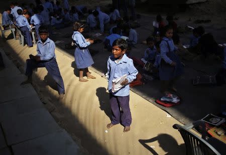 Schoolchildren attend a class at an open air school in New Delhi November 20, 2014. REUTERS/Anindito Mukherjee