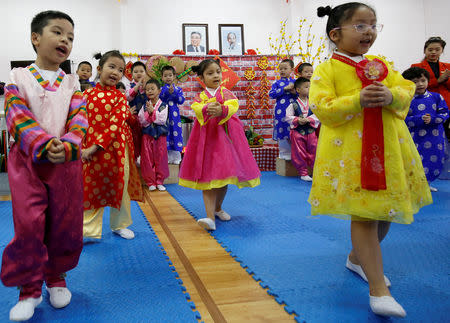 Vietnamese children play in front of images of late leaders North Korea's leader Kim Il and Vietnamese Ho Chi Minh at the Vietnam-North Korea Friendship kindergarten, founded by North Korean Government in Hanoi, Vietnam February 13, 2019. Picture taken February 13, 2019. REUTERS/Kham TPX IMAGES OF THE DAY