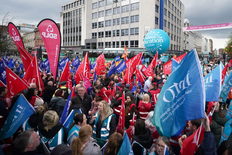Workers taking part in a rally outside Belfast City Hall in a running dispute over pay
