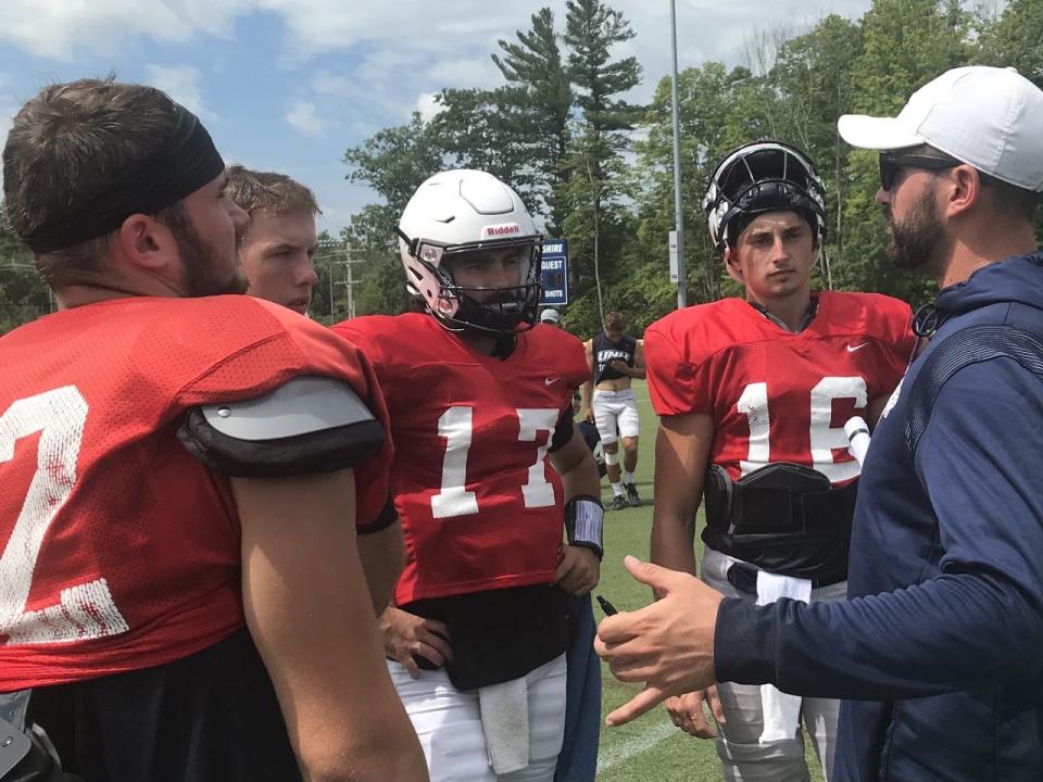 UNH quarterbacks, from left, Brody McAndrew, Barry Kleinpeter, Bret Edwards and Max Brosmer talk with quarterbacks coach Drew Belcher at a recent practice.