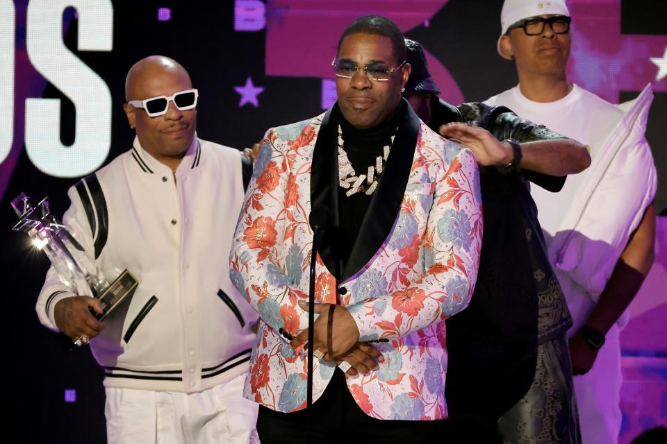 Busta Rhymes, center, accepts the Lifetime Achievement Award from Spliff Star, far left, and Swizz Beatz, right, onstage during the BET Awards 2023.