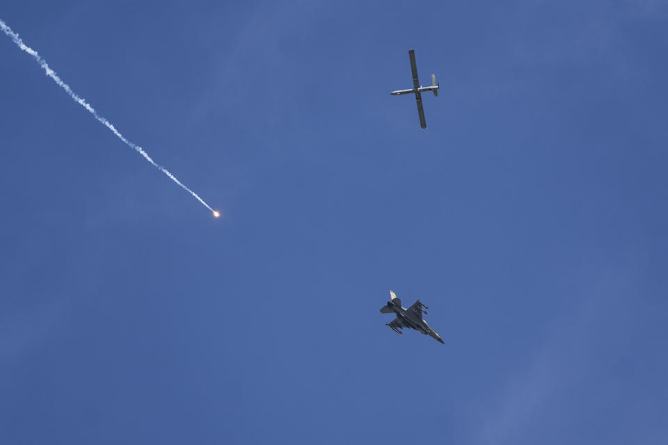 An Israeli fighter jet releases flares, and a drone is seen from Rafah, Gaza Strip, on Tuesday, May 28, 2024. (AP Photo/Abdel Kareem Hana)