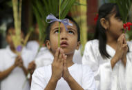 A Filipino boy participates in Palm Sunday rites outside the Holy Family Parish Church in Quezon city, north of Manila, Philippines on Sunday, April 13, 2014. Palm Sunday marks the triumphant entry of Jesus Christ into Jerusalem and ushers in the Holy Week observance among Catholics worldwide. (AP Photo/Aaron Favila)