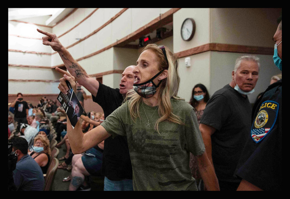 Protesters against a COVID-19 mandate gesture as they are escorted out of the Clark County School Board meeting at the Clark County Government Center, in Las Vegas, on Aug. 12, 2021.<span class="copyright">Bizuayehu Tesfaye—Las Vegas Review-Journal/AP</span>