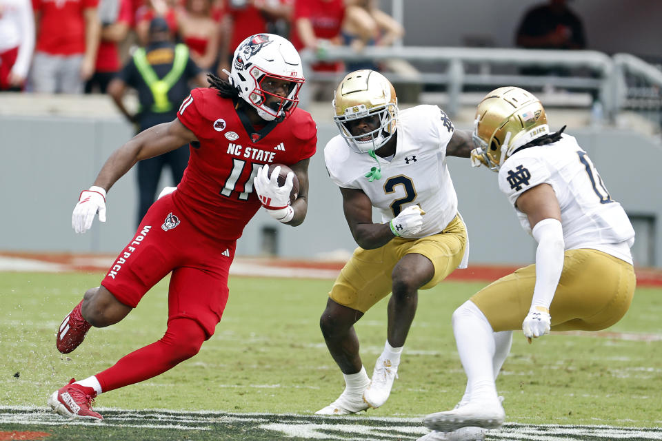 North Carolina State's Juice Vereen (11) tried to avoid the tackles of Notre Dame's DJ Brown (2) and Xavier Watts (0) during the first half of an NCAA college football game in Raleigh, N.C., Saturday, Sept. 9, 2023. (AP Photo/Karl B DeBlaker)