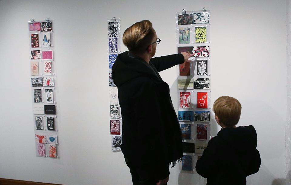 Paul Bruski and his son Brody Bruski looks around the displayed postcard in a Postcard Exhibition at Iowa State University Memorial Union Building on Monday, Jan. 22, in Ames, Iowa.