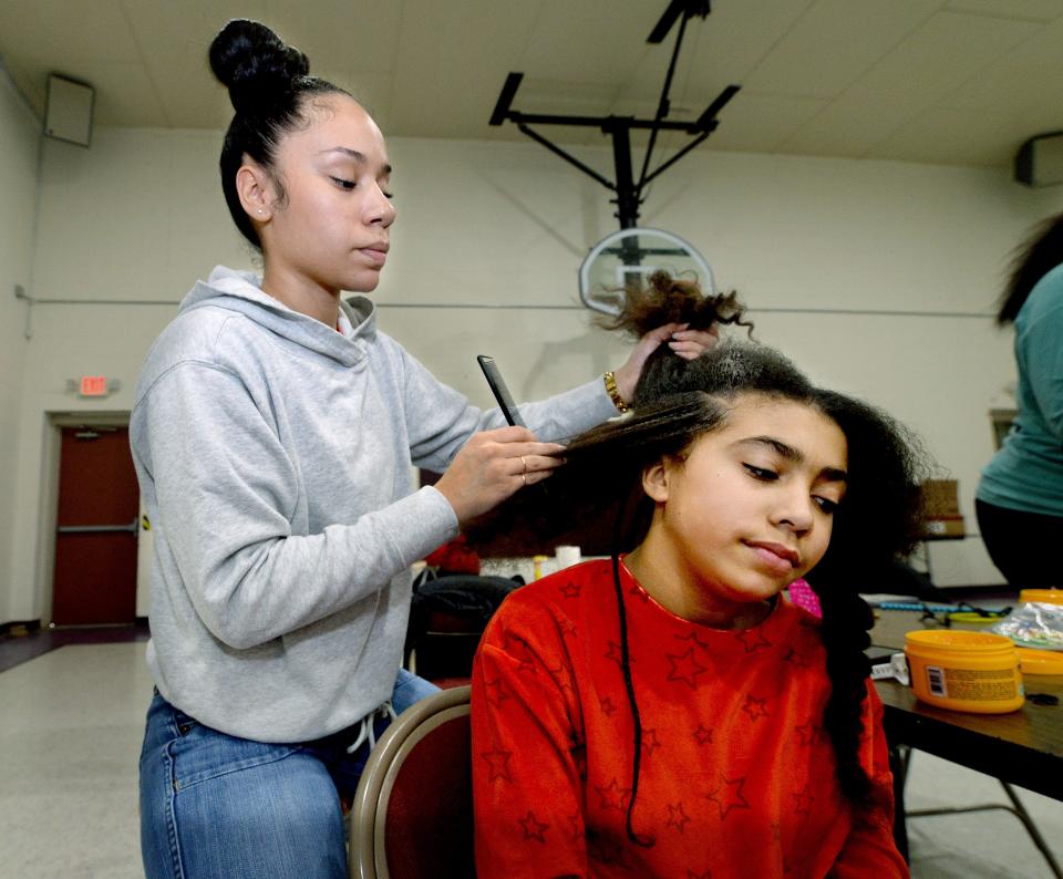 Novella Fedor, 11 of Springfield, right, gets her hair braided by volunteer Destiny Riley also of Springfield at the Pleasant Grove Baptist Church Saturday Dec. 17, 2022.