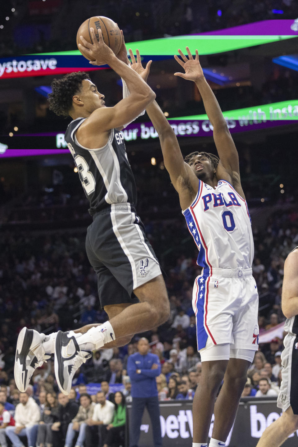 San Antonio Spurs guard Tre Jones (33) takes a shot over Philadelphia 76ers guard Tyrese Maxey (0) in the first half on an NBA basketball game, Saturday, Oct. 22, 2022, in Philadelphia. (AP Photo/Laurence Kesterson)