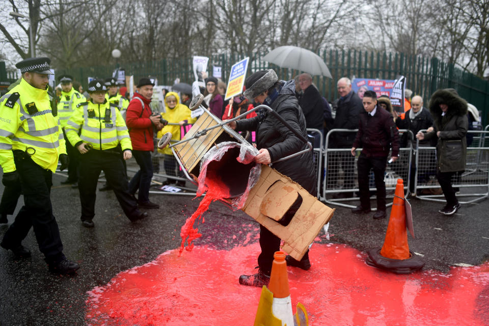 LONDON, ENGLAND - FEBRUARY 24: A protestor pours red paint on the ground in support of WikiLeaks founder Julian Assange outside Belmarsh prior to his extradition hearing on February 24, 2020 in London, England. Assange is wanted by the United States on charges related to the publication of classified US military documents and faces a possible maximum 175-year prison sentence. (Photo by Peter Summers/Getty Images)