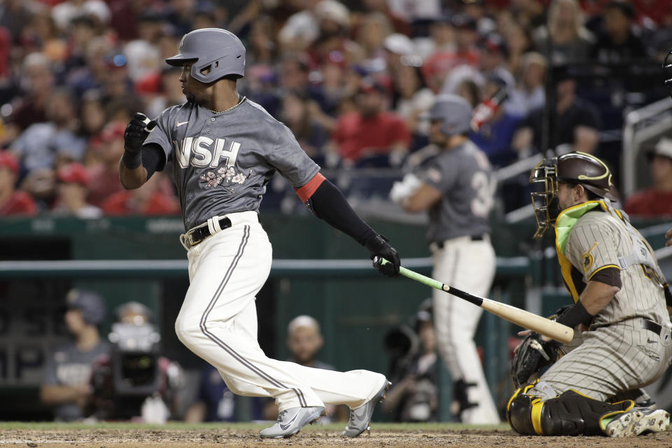 Washington Nationals' Victor Robles follows through on an RBI single during the seventh inning of the team's baseball game against the San Diego Padres, Saturday, Aug.13, 2022, in Washington. César Hernández was called out at home plate but a video review showed that catcher Austin Nola blocked the plate and the run counted. (AP Photo/Luis M. Alvarez)