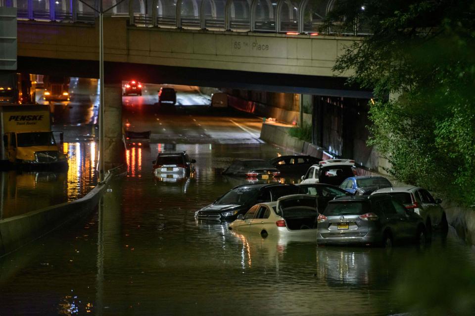 A worker unblocks drains on a street affected by floodwater in Brooklyn, New York as flash flooding and record-breaking rainfall smashed the area. Source: Getty