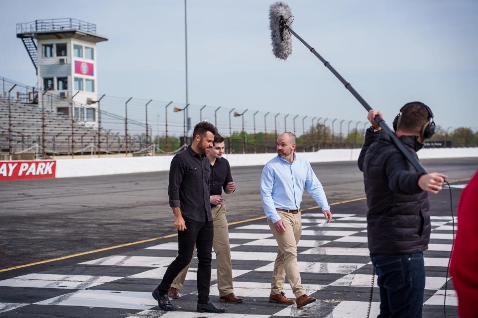 Actors Brett Varvel (left), Grant Craig (middle), and Lorin Foster make their way Thursday, April 27, 2023, across the track at Lucas Oil Indianapolis Raceway Park during their last day of filming for Mayberry Man, a comedy series based on "The Andy Griffith Show."