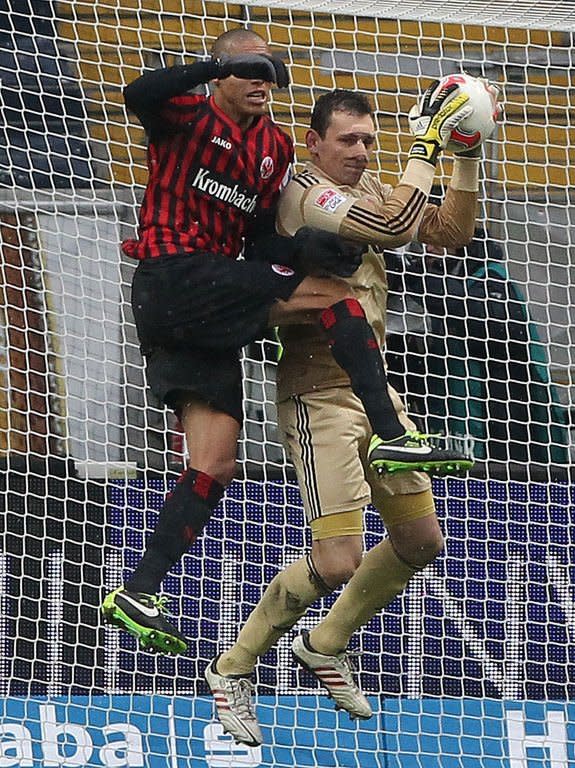 Nuremberg's goalkeeper Raphael Schaefer (R) and Frankfurt's defender Bamba Anderson fight for the ball during their German first division Bundesliga football match in Frankfurt, western Germany, on February 9, 2013. The match ended in a 0-0 draw