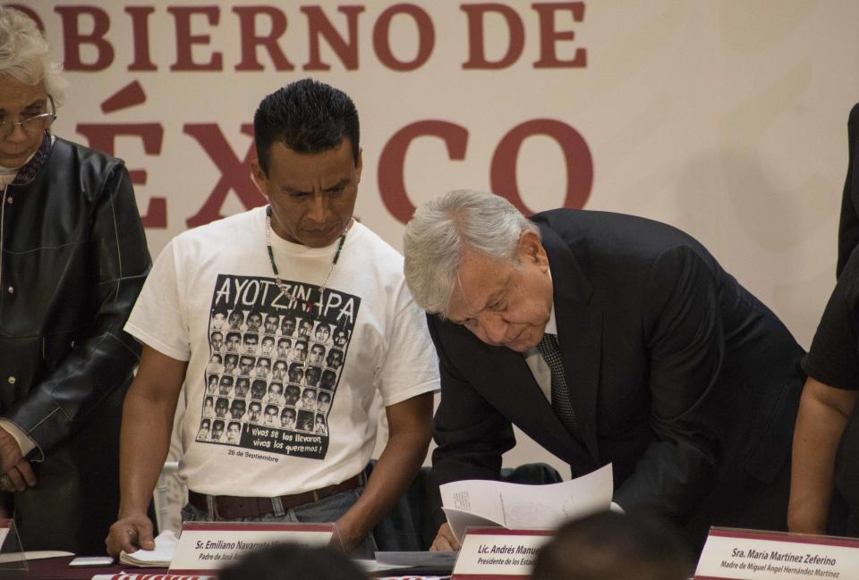 El nuevo presidente de México, Andrés Manuel López Obrador, firma un decreto que crea una comisión de la verdad para investigar la desaparición en 2014 de 43 estudiantes de la escuela de maestros de Ayotzinapa en una aparente masacre en el estado mexicano de Guerrero, durante una ceremonia en el Palacio Nacional de la Ciudad de México, el lunes 3 de diciembre de 2018. ( AP Foto / Christian Palma)