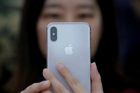 FILE PHOTO: A attendee uses a new iPhone X during a presentation for the media in Beijing