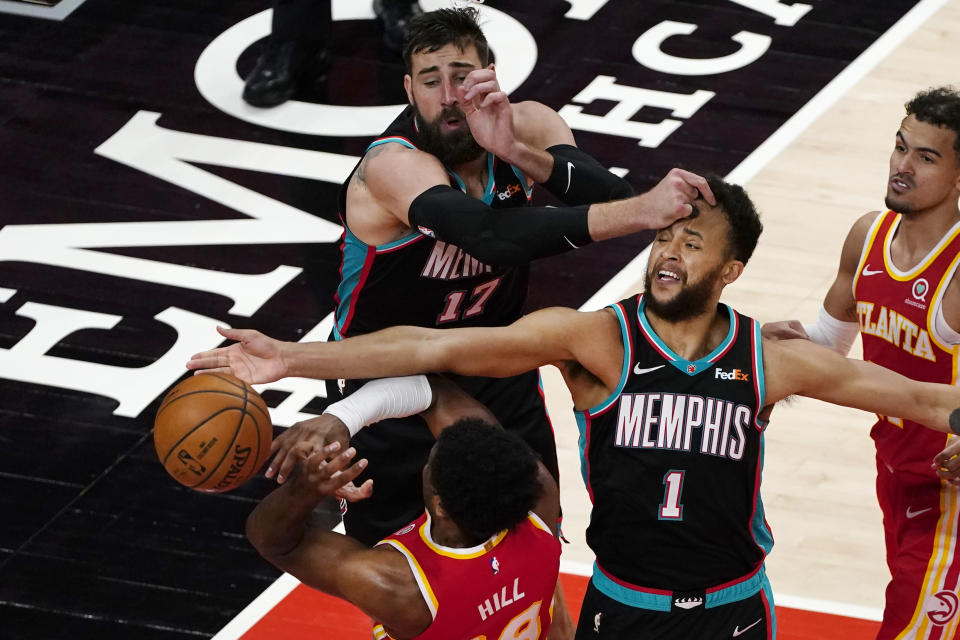 Atlanta Hawks forward Solomon Hill (18) has is defended by Memphis Grizzlies Kyle Anderson (1) and Jonas Valanciunas (17) in the second half of an NBA basketball game Wednesday, April 7, 2021, in Atlanta. (AP Photo/John Bazemore)