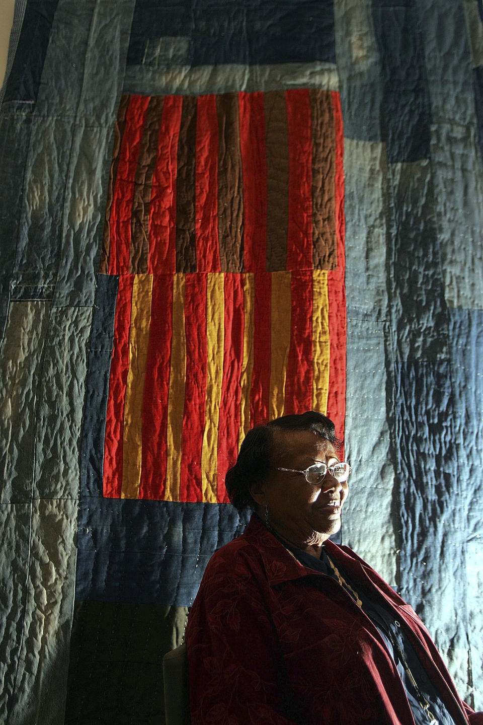 FILE - Quilter Annie Mae Young, of the Gee's Bend area in Alabama, poses in front of her quilt at the Museum of Fine Arts in Boston, May 31, 2005. Target launched a limited-edition collection based on the Gee’s Bend quilters' designs for Black History Month in 2024. The Target designs were “inspired by” five Gee's Bend quilters who reaped limited financial benefits from the collection’s success. (AP Photo/Chitose Suzuki, File)