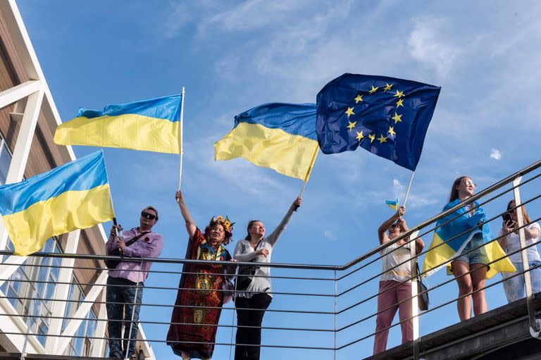 Un grupo de personas ondea banderas europeas y ucranianas durante una manifestación en solidaridad con Ucrania en la ciudad portuaria de Limassol, al sur de Chipre, mientras los europeos conmemoran la victoria de los Aliados contra la Alemania nazi y el fin de la Segunda Guerra Mundial en Europa (Día de la Victoria), el 8 de mayo de 2022.