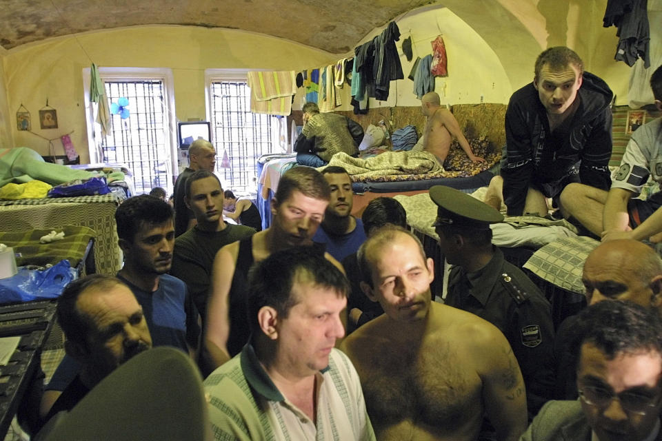 FILE - Prisoners inside Moscow's 18th century Butyrka prison talk to officials and a visiting British delegation on June 5, 2002. Former inmates, their relatives and human rights advocates paint a bleak picture of Russia’s prison system that is descended from the USSR's gulag. For political prisoners, life inside is a grim reality of physical and psychological pressure. (AP Photo, File)